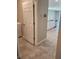 Hallway view leading to a modern kitchen with white cabinets and stainless appliances at 1808 Carnostie Rd, Winter Haven, FL 33884