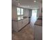 Open-concept kitchen featuring a granite island with stainless steel appliances and tile floors at 1808 Carnostie Rd, Winter Haven, FL 33884