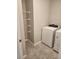 A clean laundry room with a modern washer and dryer plus shelving at 1808 Carnostie Rd, Winter Haven, FL 33884