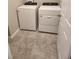 Well-lit laundry room with matching washer and dryer set on tile floor at 1808 Carnostie Rd, Winter Haven, FL 33884
