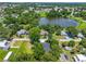 Aerial view showcases a home near a serene lake, surrounded by lush greenery, and neighboring residential properties at 201 Hillside Ave, Umatilla, FL 32784