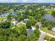 Aerial view capturing the home's setting among trees and adjacent to a lake at 201 Hillside Ave, Umatilla, FL 32784