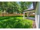Spacious backyard featuring lush green grass, privacy fence, and a covered patio, ideal for outdoor activities at 201 Hillside Ave, Umatilla, FL 32784