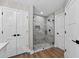Modern bathroom featuring glass shower doors, marble tile, and wood-look flooring at 201 Hillside Ave, Umatilla, FL 32784