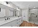Modern bathroom with double vanities, a glass-enclosed shower, and stylish fixtures at 201 Hillside Ave, Umatilla, FL 32784