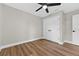This bedroom has wood-look floors, a ceiling fan, and a spacious closet at 201 Hillside Ave, Umatilla, FL 32784