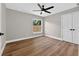 Bright bedroom features wood-look floors, modern ceiling fan and natural light from window at 201 Hillside Ave, Umatilla, FL 32784