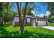 Charming home exterior showcasing a well-manicured lawn and attached garage at 201 Hillside Ave, Umatilla, FL 32784