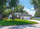 Charming home exterior featuring a well-maintained lawn, stone accents, and a two-car garage for added curb appeal at 201 Hillside Ave, Umatilla, FL 32784