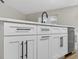 Kitchen island featuring white cabinets, stainless steel appliances, quartz countertops, and black hardware at 201 Hillside Ave, Umatilla, FL 32784