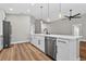 Open concept kitchen with stainless steel appliances, white cabinets, island with sink, and wood flooring at 201 Hillside Ave, Umatilla, FL 32784