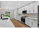 Modern kitchen with white cabinets, quartz countertops, and stainless steel appliances at 201 Hillside Ave, Umatilla, FL 32784