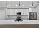 Modern kitchen featuring white cabinets, stainless steel appliances, marble backsplash, and quartz countertops at 201 Hillside Ave, Umatilla, FL 32784