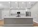 Modern kitchen with white cabinets, quartz countertops, stainless steel appliances, and stylish pendant lighting at 201 Hillside Ave, Umatilla, FL 32784