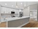 Modern kitchen with pendant lights, white cabinets, stainless appliances, and center island at 201 Hillside Ave, Umatilla, FL 32784