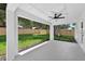 Covered patio view showcases an outdoor fan, modern design, and inviting space overlooking a well-maintained, fenced backyard at 201 Hillside Ave, Umatilla, FL 32784