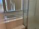 Clean bathroom showcasing a large bathtub, tiled steps, and a glass-enclosed shower at 206 Orchid Dr, Davenport, FL 33897