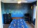 Charming bedroom with celestial-themed walls, desk area, and ceiling fan for comfort at 206 Orchid Dr, Davenport, FL 33897
