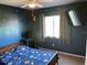 The themed bedroom features star-themed blue walls, a ceiling fan, a window, and a mounted TV at 206 Orchid Dr, Davenport, FL 33897