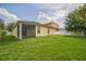 Spacious backyard featuring a lush green lawn, enclosed porch, and a partial white fence at 236 Savannah Preserve Loop, Davenport, FL 33837