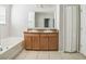 Bathroom featuring double vanity, framed mirror, soaking tub and tile flooring at 236 Savannah Preserve Loop, Davenport, FL 33837