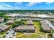Aerial view shows a brick apartment complex near shopping and entertainment, surrounded by lush greenery at 2423 Branch Way # 207, Maitland, FL 32751