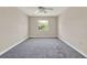 Neutral bedroom with a ceiling fan, plush carpet, and natural light from the window at 2423 Branch Way # 207, Maitland, FL 32751