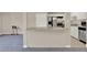 Modern kitchen with stainless steel appliances, white cabinetry, and a breakfast bar overlooking the living area at 2423 Branch Way # 207, Maitland, FL 32751