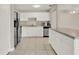 Bright kitchen with stainless steel appliances, white cabinets, tile floors, and a breakfast bar at 2423 Branch Way # 207, Maitland, FL 32751
