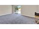 Spacious living room featuring neutral walls, plush carpeting, and a sliding glass door to the balcony at 2423 Branch Way # 207, Maitland, FL 32751