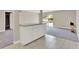 Open living area with tile flooring, slider to patio, and kitchen bar overlooking carpeted living area at 2423 Branch Way # 207, Maitland, FL 32751