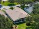 Aerial view showcasing a home with mature trees, a well-kept lawn, and large screened-in lanai at 25243 River Crest Dr, Leesburg, FL 34748