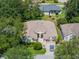 Aerial view of a well-maintained home with a two-car garage, lush landscaping, and a paved driveway at 25243 River Crest Dr, Leesburg, FL 34748