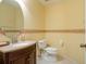 Well-lit half-bathroom with a stylish vanity, decorative mirror, and clean fixtures at 25243 River Crest Dr, Leesburg, FL 34748