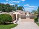 Charming home featuring a brick driveway, well-maintained landscaping, and a welcoming two-car garage at 25243 River Crest Dr, Leesburg, FL 34748