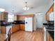 Functional kitchen with wood cabinets, laminate floors, modern appliances, and access to dining area at 25243 River Crest Dr, Leesburg, FL 34748