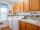 Bright laundry room featuring cabinetry, utility sink, and washer and dryer at 25243 River Crest Dr, Leesburg, FL 34748