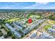 Aerial view of residential community with lush landscaping, a pond, and nearby amenities at 2530 Maneshaw Ln, Kissimmee, FL 34747