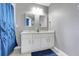 Bright bathroom featuring a double sink vanity with granite countertop and ample storage space at 2530 Maneshaw Ln, Kissimmee, FL 34747