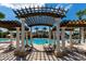 Relax and unwind at the community pool, complete with shady pergolas and comfortable lounge seating at 2530 Maneshaw Ln, Kissimmee, FL 34747