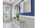 Stylish foyer with modern console table, decorative mirrors, and natural light at 2530 Maneshaw Ln, Kissimmee, FL 34747