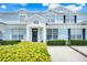 Charming townhome with light blue exterior, dark blue shutters, and manicured landscaping at 2530 Maneshaw Ln, Kissimmee, FL 34747