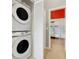 Convenient laundry area featuring a stacked washer and dryer unit, maximizing space efficiency and functionality at 2530 Maneshaw Ln, Kissimmee, FL 34747