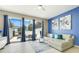 Bright living room with tile floors, blue accent wall, and sliding glass doors to pool area at 2530 Maneshaw Ln, Kissimmee, FL 34747