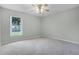 Spacious bedroom with carpet, a ceiling fan, and a window providing natural light at 2711 Bayview Dr, Eustis, FL 32726