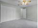 Bedroom featuring carpet, a ceiling fan, closet doors, and a view into another room at 2711 Bayview Dr, Eustis, FL 32726