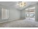 Spacious bedroom features large window, glass sliding door, and ceiling fan at 2711 Bayview Dr, Eustis, FL 32726
