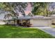 Charming home featuring a manicured lawn, arched entryway, and a two-car garage at 2711 Bayview Dr, Eustis, FL 32726
