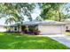 Charming single-story home featuring a well-manicured lawn, mature trees, and an attached two-car garage at 2711 Bayview Dr, Eustis, FL 32726