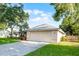 A well-maintained house with a two-car garage and a concrete driveway, surrounded by lush greenery and mature trees at 2711 Bayview Dr, Eustis, FL 32726